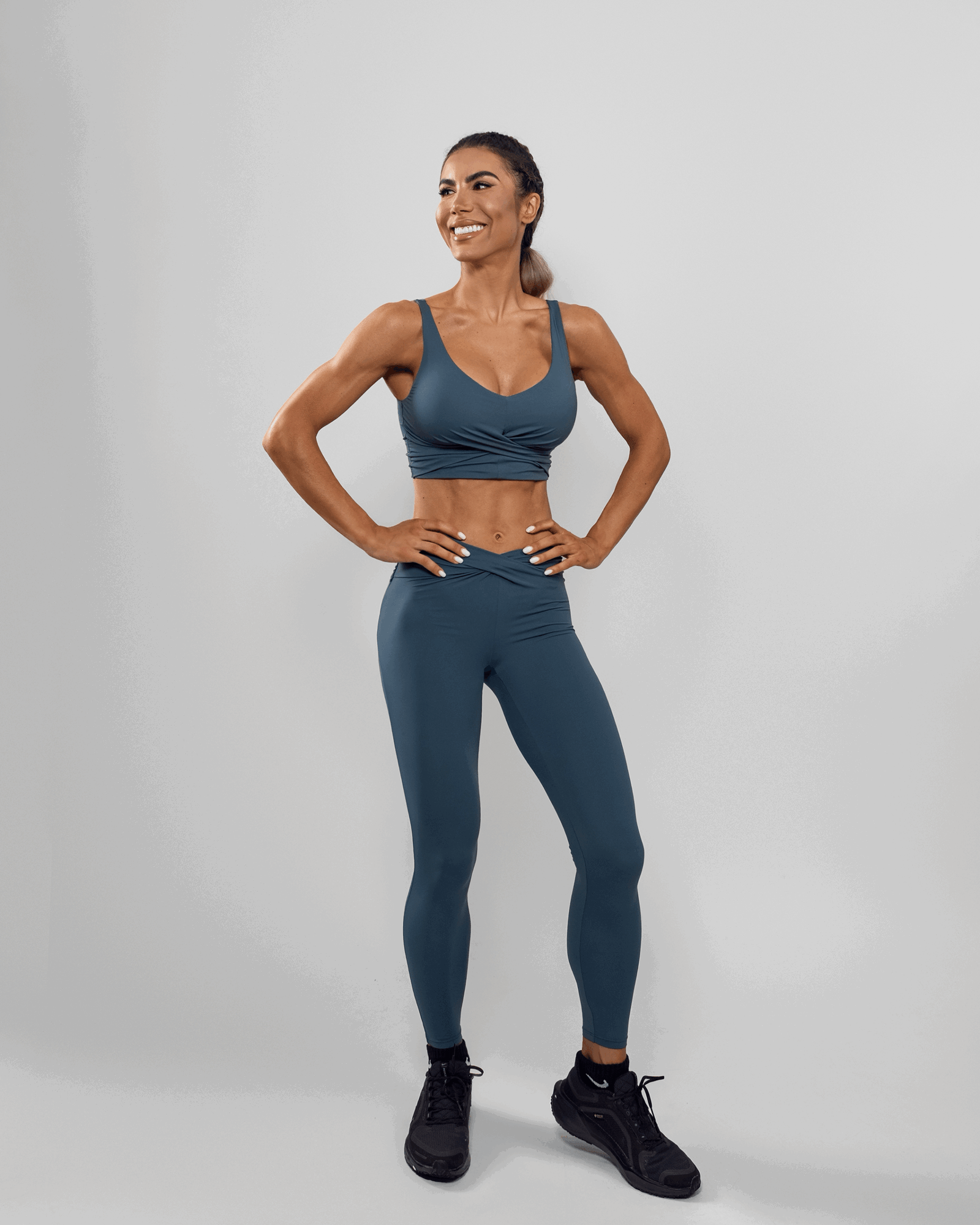 Bonita stoji u crnom topu i crvenim tajicama, smije se