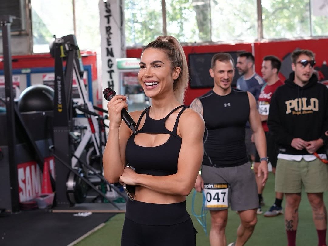 Bonita stoji u crnom topu i crvenim tajicama, smije se